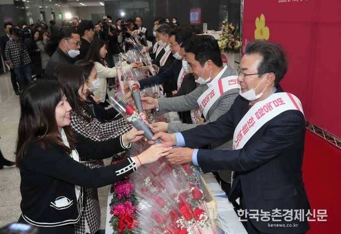 농협은 신종 코로나바이러스(코로나19) 발생으로 어려움을 겪고 있는 화훼농가를 돕기 위해 13일 서울 중구 농협중앙회 본관에서 화훼류 소비촉진 행사를 열었다. 이성희 농협중앙회장(오른쪽 첫 번째부터)과 우진하 금융노조 NH농협지부 위원장이 출근하는 직원들에게 꽃을 나눠주고 있다. kenews.co.kr<br>
