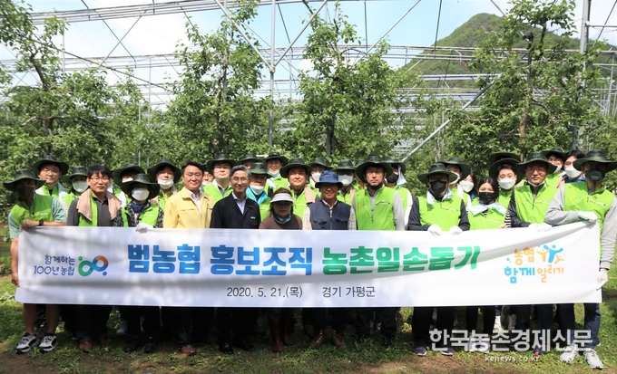 범농협 홍보조직 임직원들이 21일 경기 가평군 소재 사과 농가에서 일손돕기를 하기 전 기념촬영을 하고 있다. kenews.co.kr