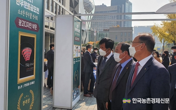 한국프레스센터앞 야외전시장에서 공모전 수상작을 보는 모습(우측부터 김태환농협축산경제대표이사 김삼주 전국한우협회장, 민경천 한우자조금관리위원장). kenews.co.kr