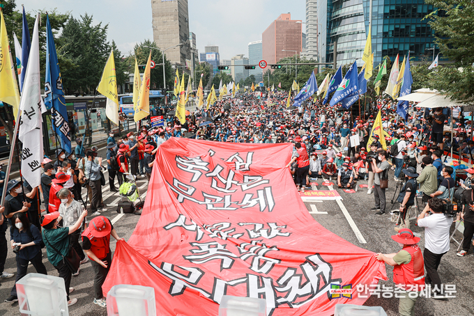 8월 11일 서울역 12번출구에서 열린 '축산 생존권 사수 총궐기대회'에 참석한 축산농가들이 수입축산물 무관세와 사료값 폭등 무대책' 이 적힌 대형 현수막을 찢는 상징의식을 벌이고 있다. 이날 모인 축산농가들은 정부에 경영안정을 위한 사룟값 안정대책과 식량안보 및 자급률 안정을 위한 구체적인 대책을 수립을 촉구했다. <사진제공= 비상대책위원회 kenews.co.kr>