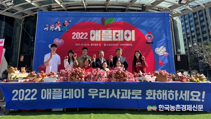농협경제지주는 10월 24일 애플데이를 기념해 서울 종로구 광화문 동아미디어센터에서 '2022 애플데이 기념 햇사과 나눔행사'를 개최했다. 이날 농협은 가족, 지인 등에게 사과의 메시지를 전하는 보드판 행사와 세척사과 나눔 등을 진행해 시민 참여자들의 호응을 이끌었다(왼쪽 세번째부터 이천일 농협경제지주 품목지원본부장, 윤수현 농협사과전국협의회장(거창사과원예농협조합장), 남정순 농협사과전국협의회 부회장(영주농협조합장)). kenews.co.kr