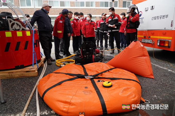 남성현 산림청장(가운데)이 24일 강원도 고성군 경동대학교 글로벌캠퍼스에서 열린 '2022년 산불합동진화 및 안전한국 시범훈련'에 참석, 이동형 물주머니에 대해 설명을 듣고 있다.<사진=산림청 제공 kenews.co.kr>