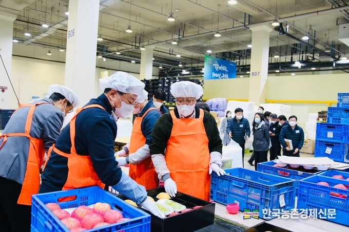 농협경제지주와 기획재정부는 12일 경기도 화성시 농협안성농식품물류센터를 방문해 설 명절 성수품 수급상황과 가격동향을 점검했다.사진은 안성물류센터를 찾은 염기동 농협경제지주 산지도매본부장(앞줄 오른쪽)과 방기선 기획재정부 1차관(앞줄 왼쪽)이 사과, 배 선물세트 소포장 작업을 하는 모습. kenews.co.kr