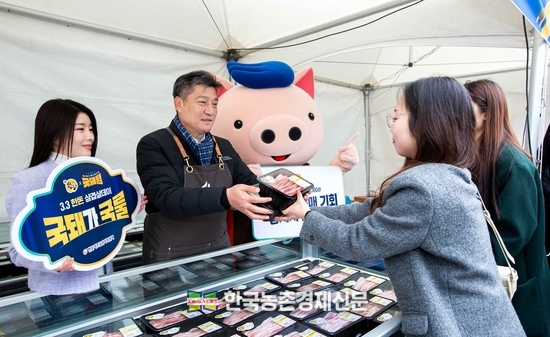 한돈자조금 손세희 위원장이 한돈 할인 판매 행사장을 찾은 소비자들에게 한돈 삼겹살을 판매하고 있다.kenews.co.kr