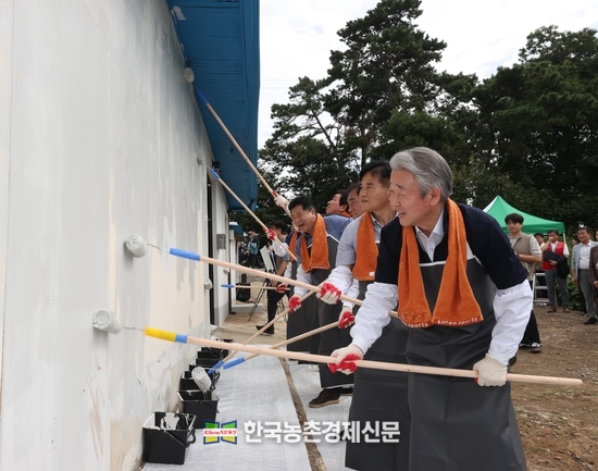 강호동 농협중앙회장(오른쪽)은 경기 평택시 포승읍에서 열린 ‘사랑의 집고치기 봉사활동’에 참여해 주택 담장을 페인트칠하고 있다. kenews.co.kr